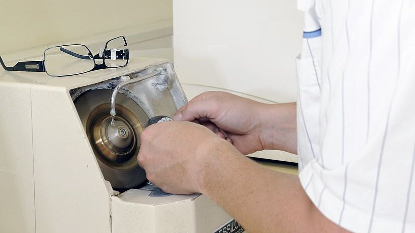 Mann arbeitet an Glasschleifmaschine