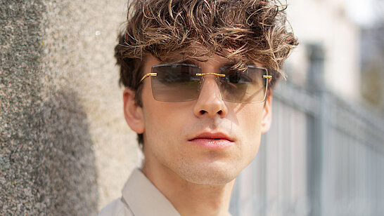 Junger Herr mit Sonnenbrille im Freien