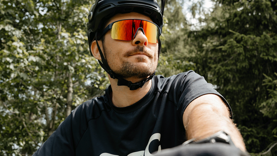 Junger Herr mit Sportbrille und Fahrradhelm
