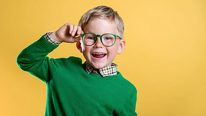 Junger Bub mit grüner, runder Brille