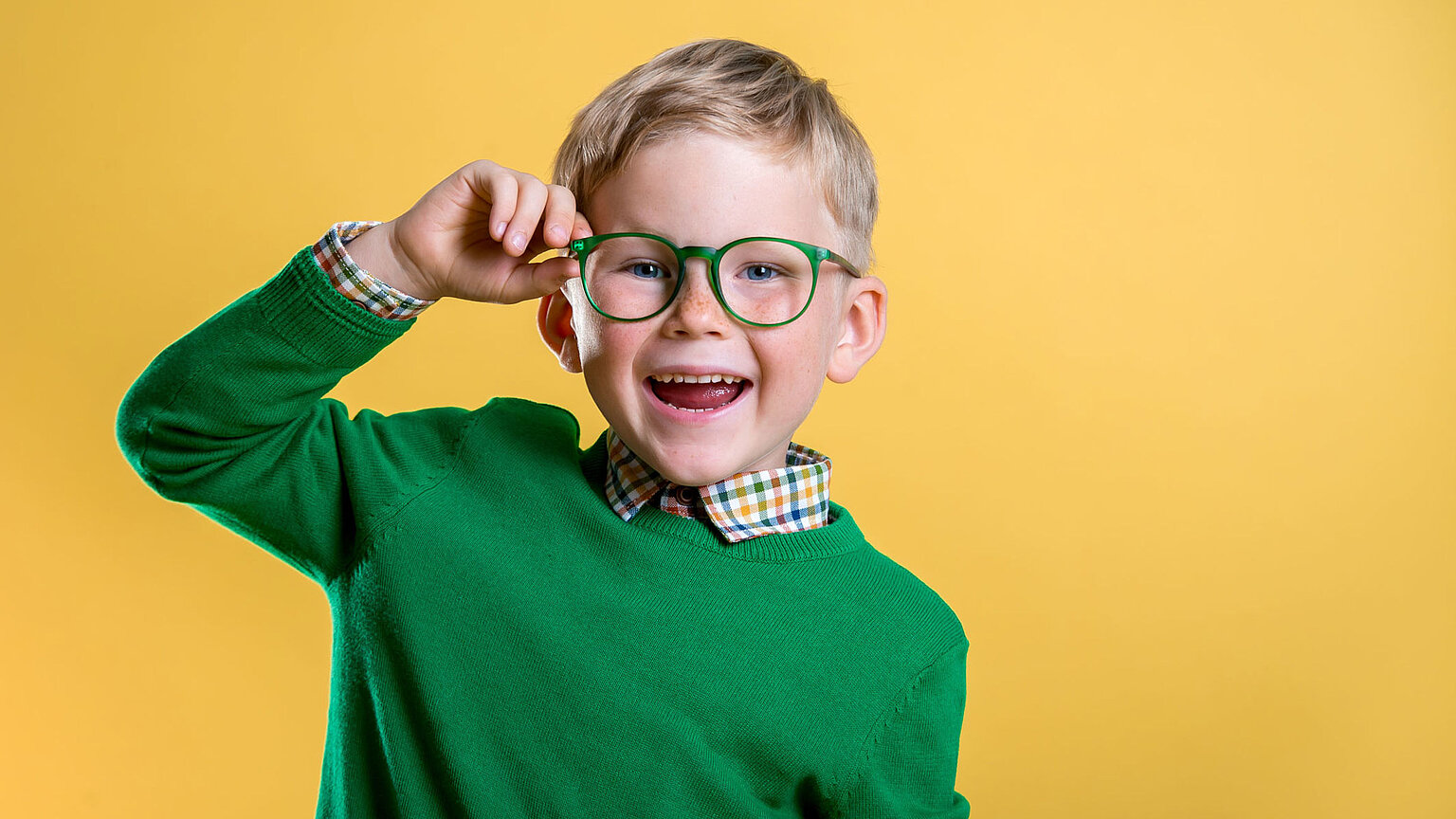 Junger Bub mit grüner, runder Brille