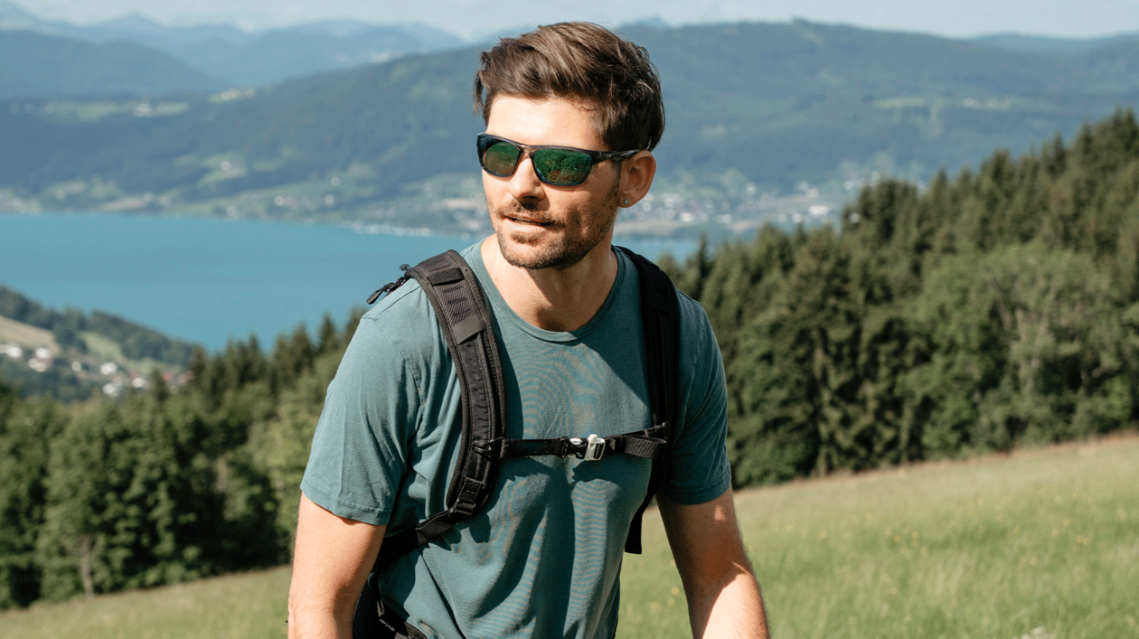 Junger Herr mit Sportbrille beim Wandern