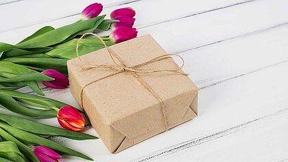 Geschenk mit Tulpen daneben