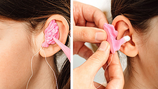 Nahaufnahme eines Ohrs beim Anpassen des Hörgeräts mit rosa Schaum