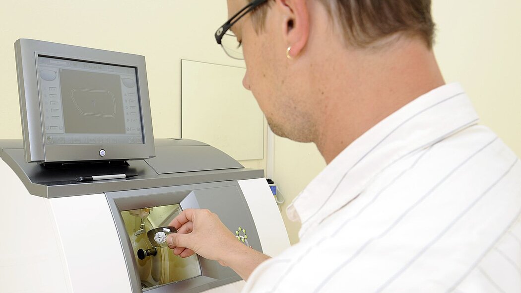 Mann arbeitet an Glasschleifmaschine