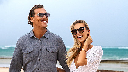 Eine Frau und ein Mann mit Sonnenbrillen am Strand