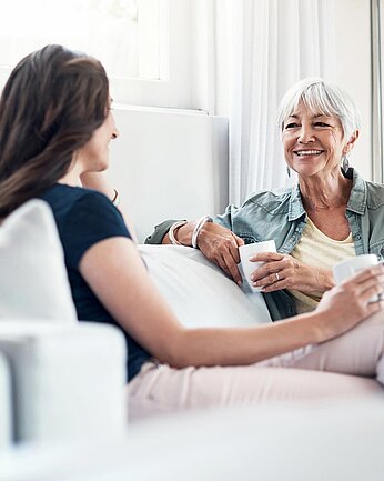 Zwei Frauen unterhalten sich auf dem Sofa