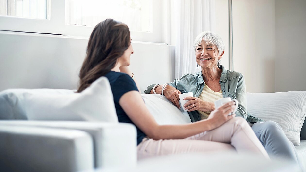 Zwei Frauen unterhalten sich auf einem Sofa