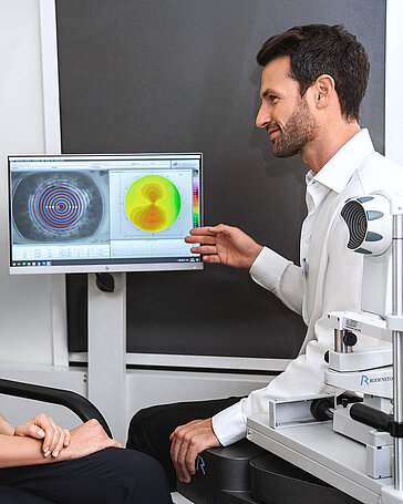 Ein United Optics Experte erklärt einer Dame Bilder am Computer