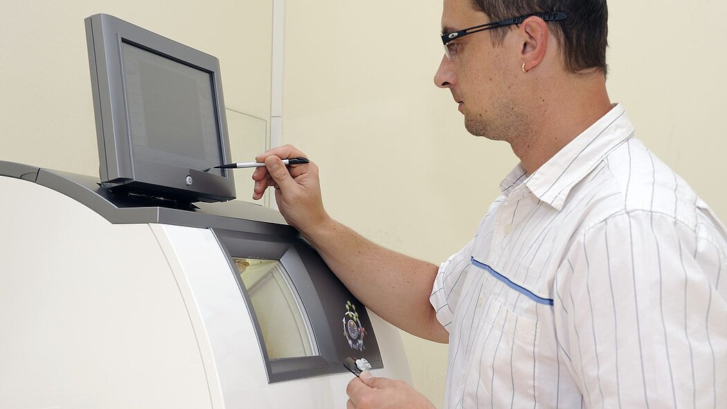 Mann arbeitet an Glasschleifmaschine