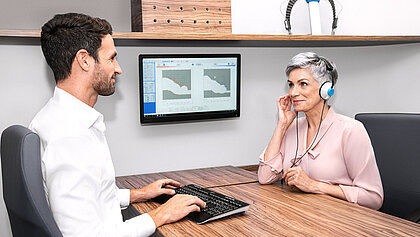 Akustik-Experte führt einen Hörtest an einer älteren Dame durch