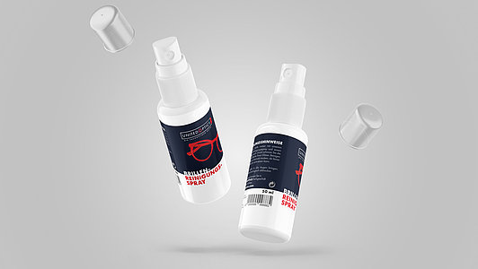 Brillenreinigungsspray vor grauem Hintergrund